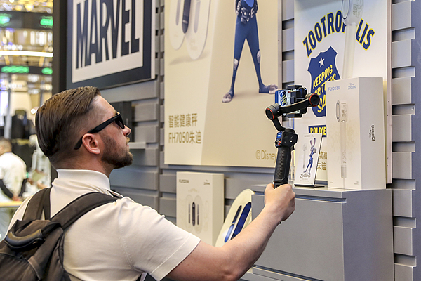 3月21日,上海,AWE中国家电及消费电子博览会。一名外国参观者在拍摄产品。 视觉中国