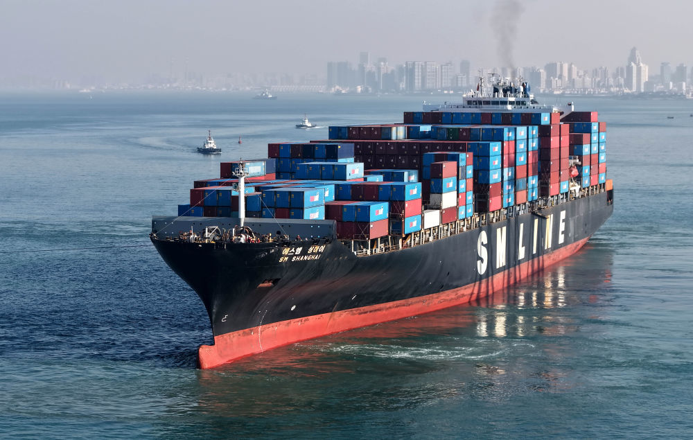 12月4日，一艘满载集装箱的货轮驶离青岛港前湾港区码头（无人机照片）。新华社记者 李紫恒 摄