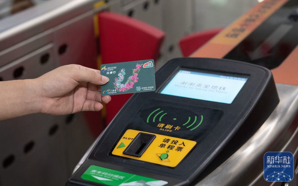↑在深圳福田站地铁闸机出口，用户持深港互通行卡准备刷卡（2023年8月30日摄）。新华社记者 毛思倩 摄