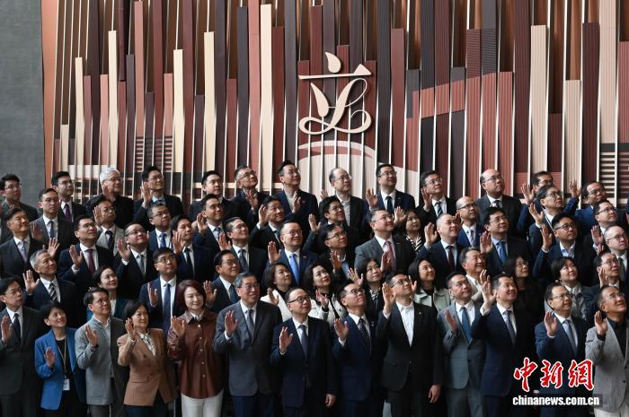 12月9日,香港特区第七届立法会议员与第八届立法会候任议员,在立法会综合大楼地下大堂会见传媒。图为第七届立法会议员与第八届立法会候任议员向传媒挥手。 中新社记者 李志华 摄