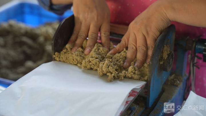 工人往封装机器中塞入艾绒
