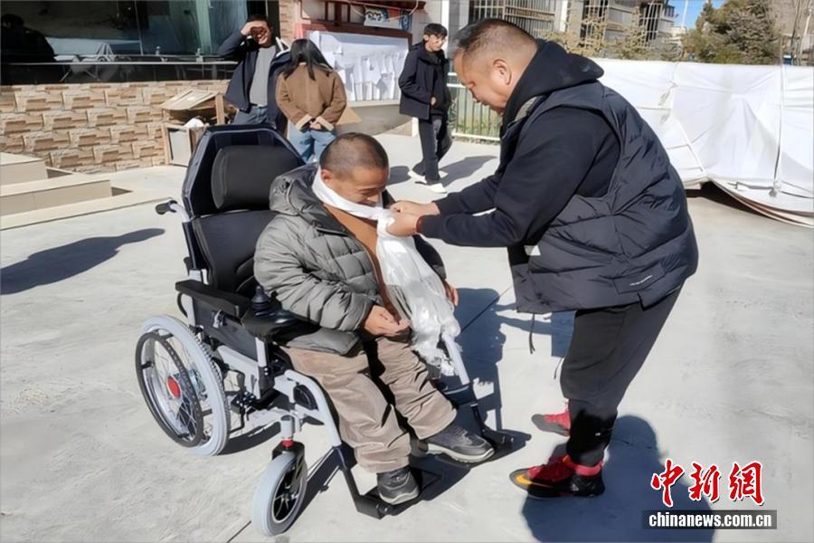 扎西平措为巴热村残障人士发放辅助设备。 受访者供图