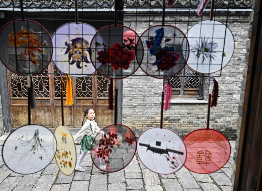 10月1日，小朋友走在盱眙县第一山历史文化街区。国庆、中秋双节期间，江苏省盱眙县推出部分景区免门票、发放消费券等惠民措施，举办丰富多彩的文旅活动。新华社记者 季春鹏 摄