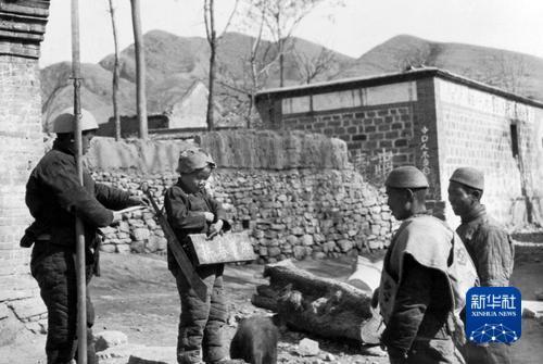 抗战时期,晋察冀边区儿童团的孩子在站岗放哨时教路过的乡民识字“加紧春耕”。沙飞 摄