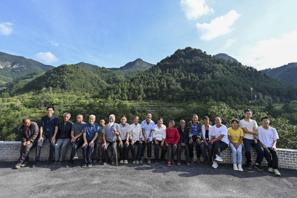 ↑照顾秦海松的部分村民和秦海松（中）合影（2025年8月27日摄）。