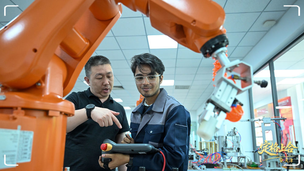 在天津现代职业技术学院鲁班工坊实训教室，教师指导来自巴基斯坦的学生操作设备。