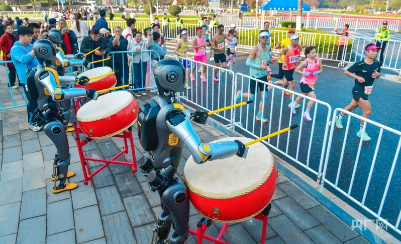 光谷马拉松现场,人形机器人为选手加油(央广网发 光谷马拉松组委会供图)