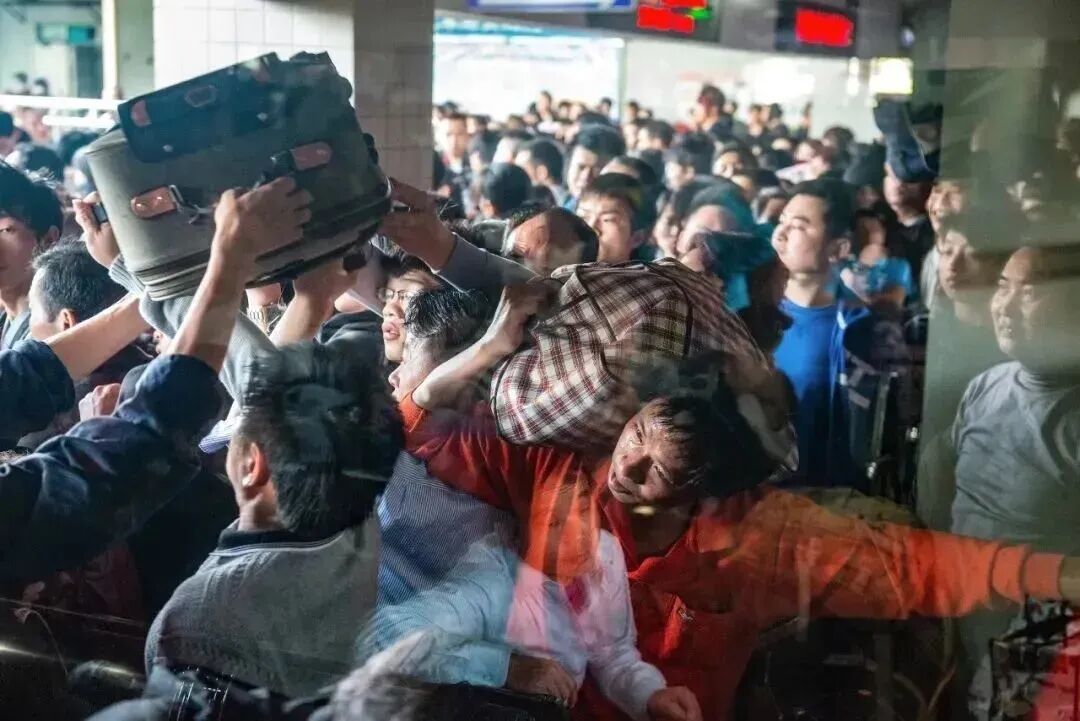 春节前,打工人在长途汽车站,准备乘长途客车返回内地的老家。汽车站内的人特别多,打工人在出发厅艰难地穿行。