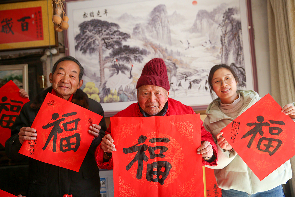 2025年1月27日,江苏南通如皋市白蒲镇勇敢社区106岁的顾汝询老人为居民写“福”字,送新春祝福。视觉中国 资料图