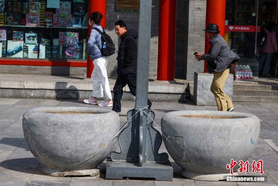 4月12日，北京前门大街被加固的石盆。当日，北京大风橙色预警信号持续生效，6时至22时为风力最强时段。中新社记者 张宇 摄