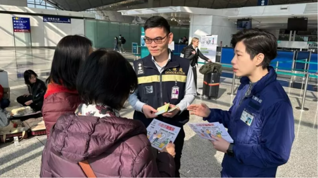 ◆1月13日，有工作人员在香港机场派发宣传单，呼吁前往东南亚国家的人小心求职诈骗陷阱。