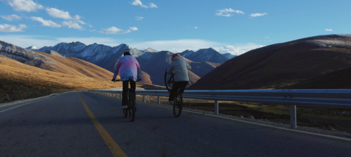 ↑旦增吉美(左)和队友在骑车的路上