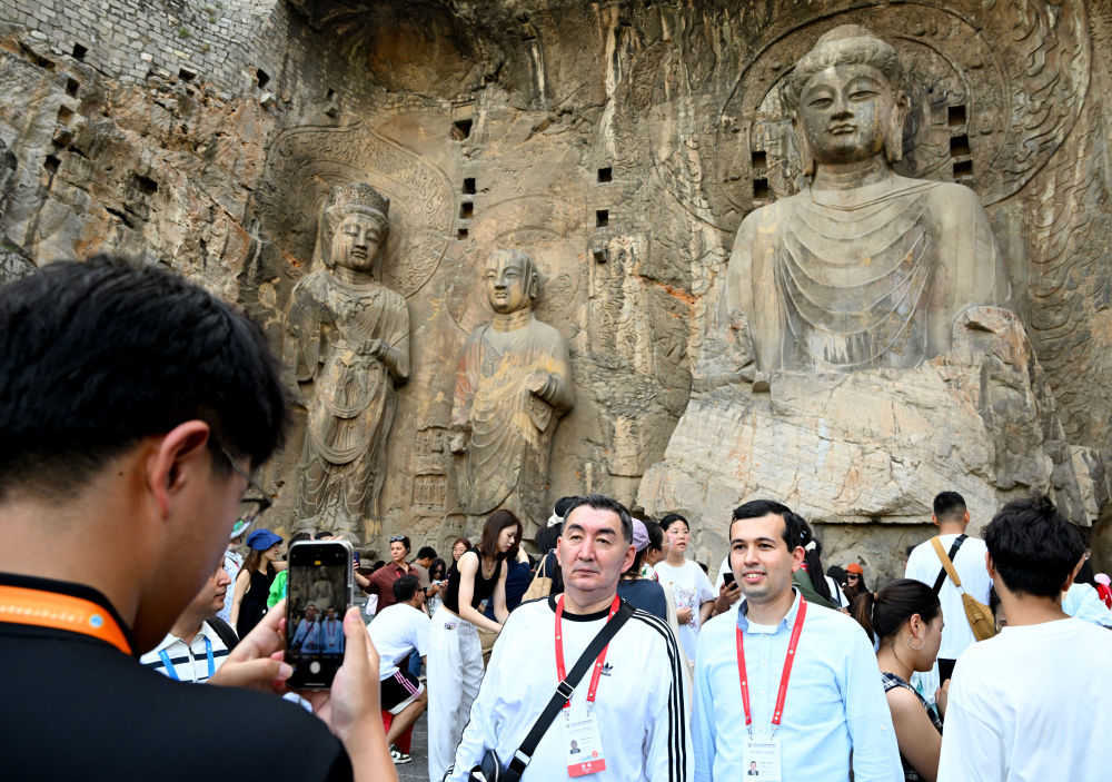 7月26日,上海合作组织媒体智库峰会与会嘉宾在河南洛阳龙门石窟合影留念。新华社记者 郝源 摄
