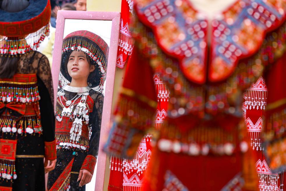 近日，在云南省红河哈尼族彝族自治州开远市的苗族集市上，少数民族群众在试穿新衣。新华社发（陶家淇 摄）
