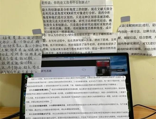 一位同学在论文写作时电脑周围贴满提示