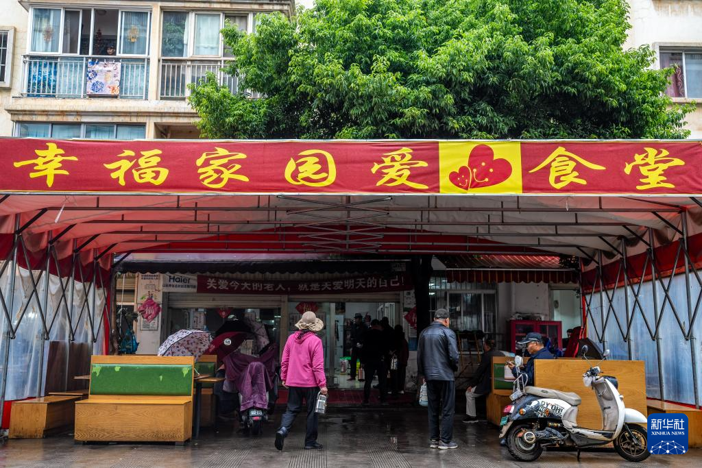 人们在昆明市幸福家园小区爱心食堂排队打饭(5月28日摄)。