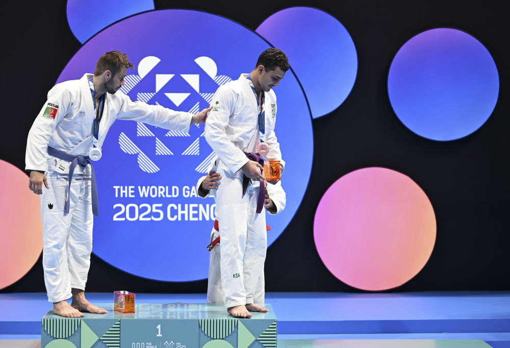 8月11日,在2025年成都世运会柔术男子寝技85公斤级颁奖仪式上,冠军阿联酋选手赛义德(后)、亚军葡萄牙选手佩德罗(左)搀扶受伤的季军沙特阿拉伯选手纳达走下领奖台。