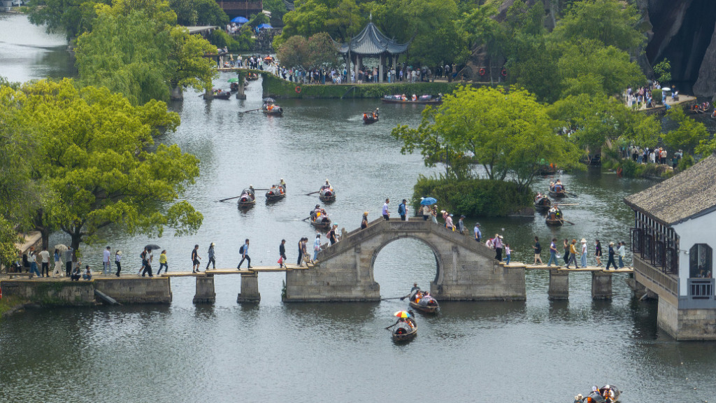 2025年5月3日,浙江省绍兴市东湖风景区,游客乘坐乌篷船游玩,感受江南水乡美景。视觉中国 图