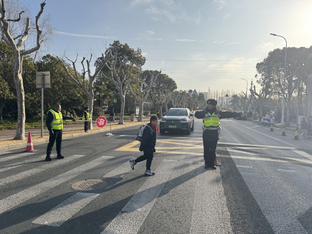 7点40分,进才实验小学西校门口前,交警指挥校门口车辆让行学生。澎湃新闻记者 徐亦嘉 图