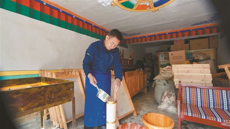 图为阿旺曲央在搅拌原料，制备纸浆。