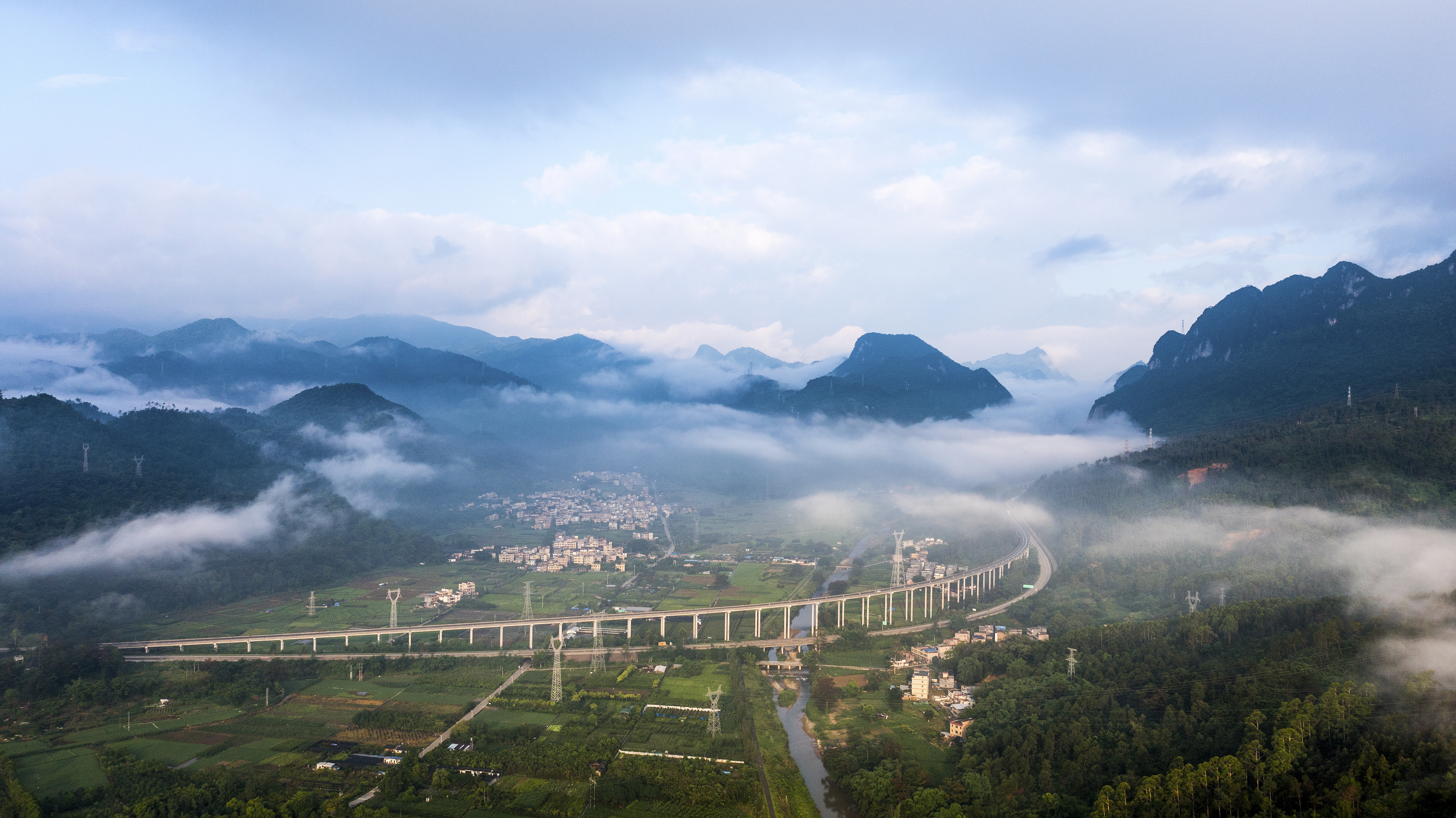 广东清远阳山县,高速公路绕过村庄,清晨云雾缭绕,远看十分壮观。南方+记者 冯国志 摄