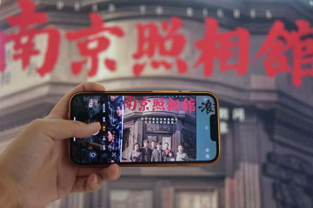 8月9日,在云南省蒙自市一电影院,观众在拍摄影片海报。新华社发(薛莹莹摄)