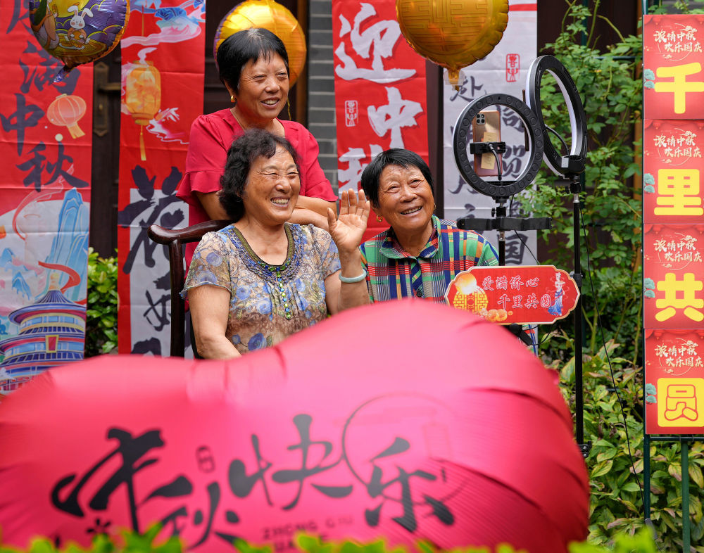 10月6日,在江苏省海安市墩头镇宝祥村“情满中秋 爱暖侨心”活动中,侨眷们与海外亲人视频连线。新华社发(周强摄)