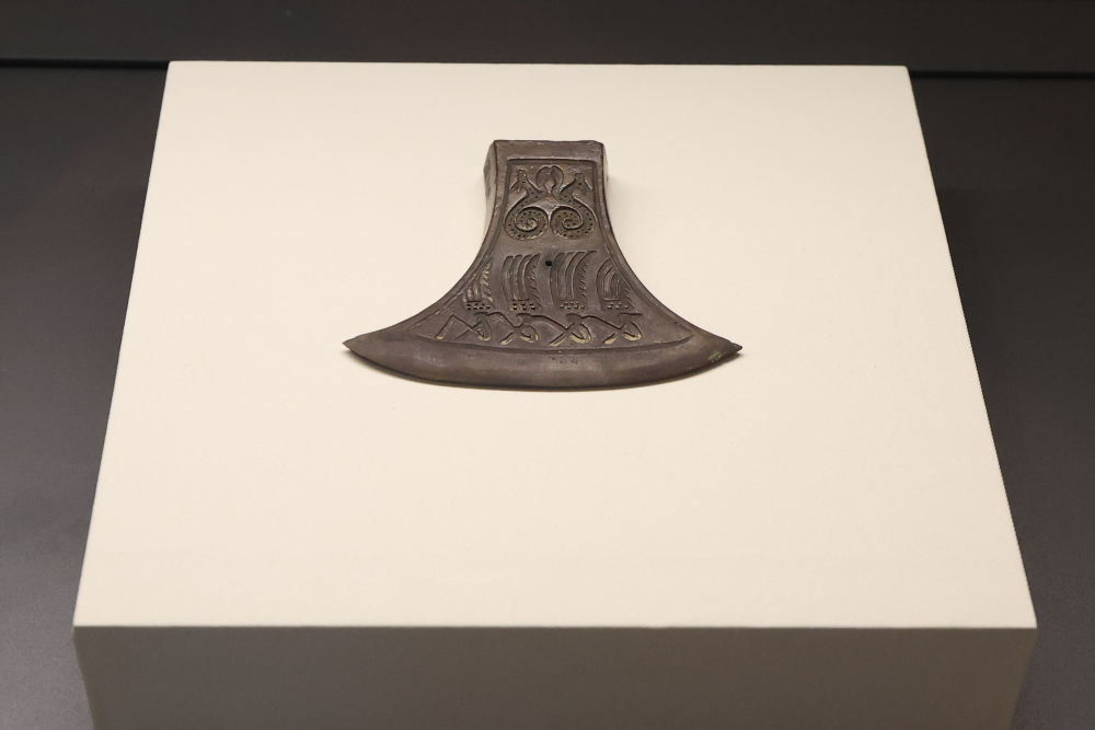 ↑图为“羽人竞渡纹铜钺”（复制品）。