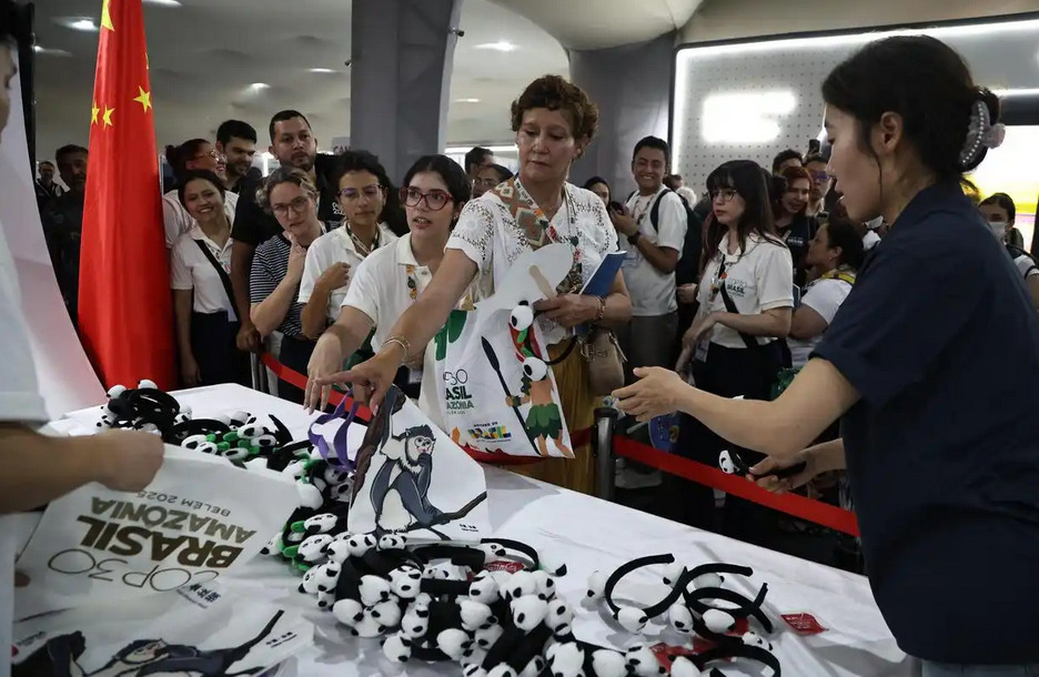 11月10日,在巴西贝伦,与会代表在COP30“中国角”领取纪念品。新华社