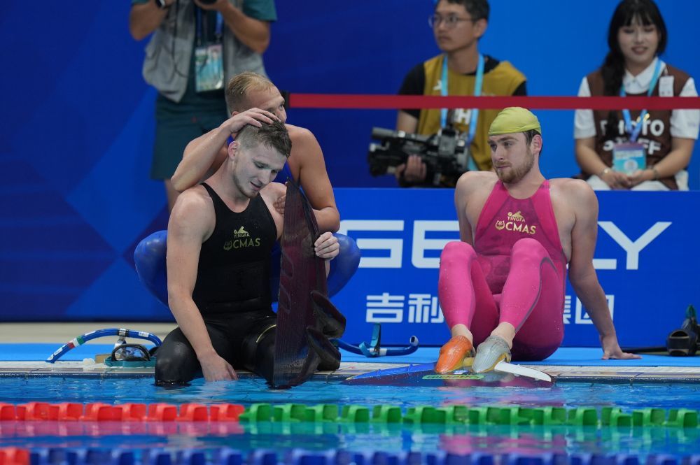 8月11日,冠军匈牙利选手基什(左)在男子200米水面蹼泳决赛后和其他选手交流。