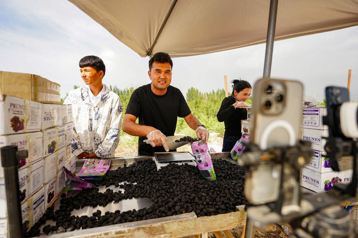 2025年6月23日，在新疆阿克苏市新疆红旗坡农贸物流园，“95后”电商米尔扎提&middot;卡米力在直播带货当地农产品。新华社记者 徐宏岩 摄