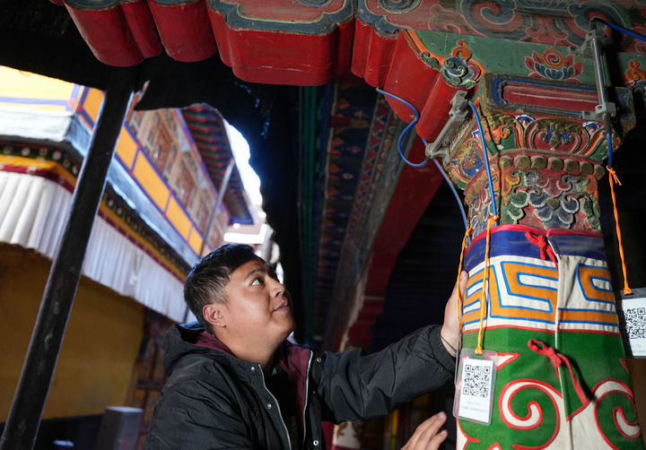 布达拉宫监测中心的工作人员旦增旺堆巡查布达拉宫木结构传感器设备（2024年12月4日摄）。新华社记者 晋美多吉 摄