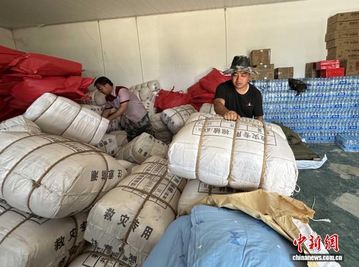 8月11日下午，榆中县马坡乡上庄村党支部书记、村委会主任陈万凯(右)和村民分拣山外送来的救灾物资。冯志军 摄