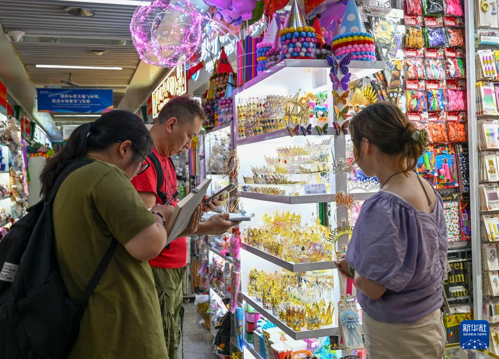 客商在浙江义乌国际商贸城记录商品信息（5月16日摄）。新华社记者 陈朔 摄