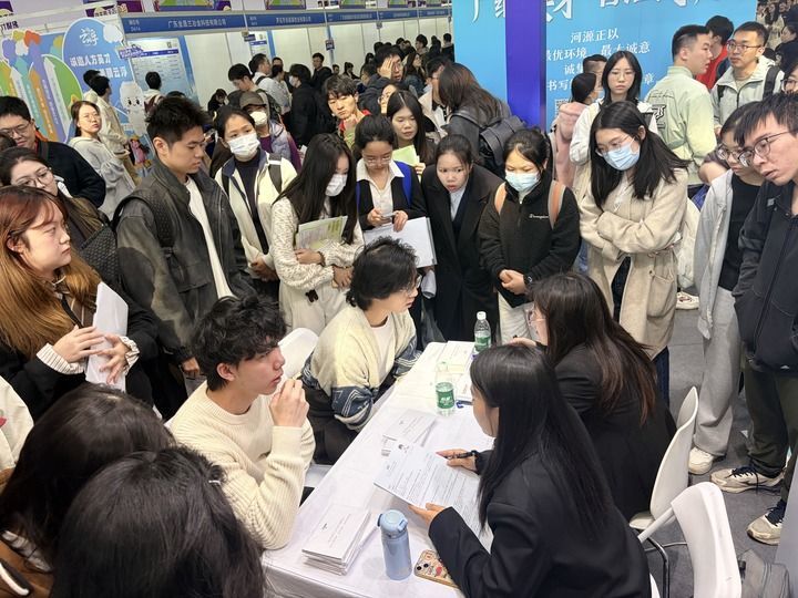 12月27日，在招聘会现场，求职者与企业招聘人员交流。新华社记者 赵瑞希 摄