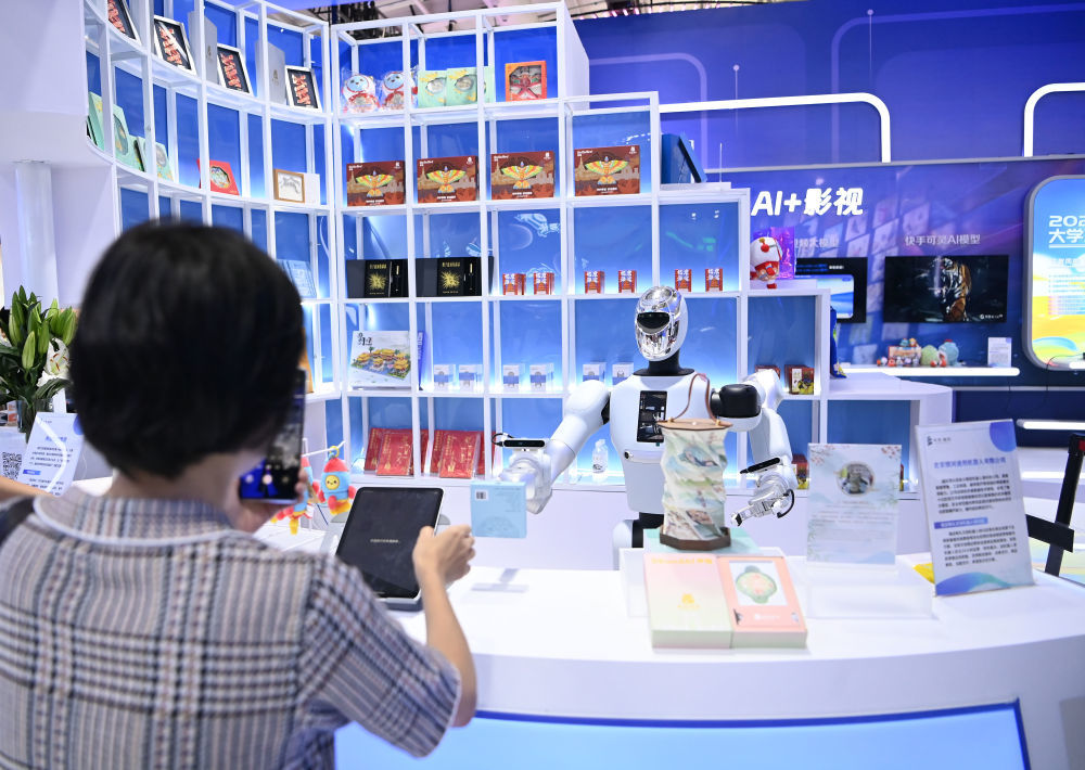 ↑ 9月11日，在服贸会文旅服务专题展区，参观者在“海淀有礼文创机器人快闪店”与机器人互动。