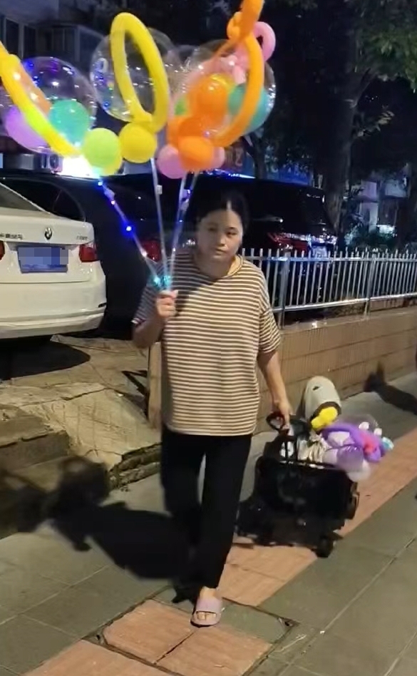 2025年7月,郭惠担心乐宝撞破头上的包,傍晚出门卖气球时常把他放在儿童车里。 受访者供图
