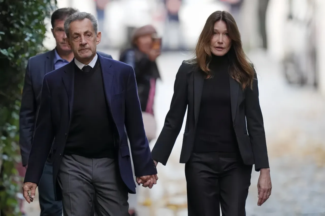 ·萨科齐在妻子的陪伴下走进监狱。(美联社)