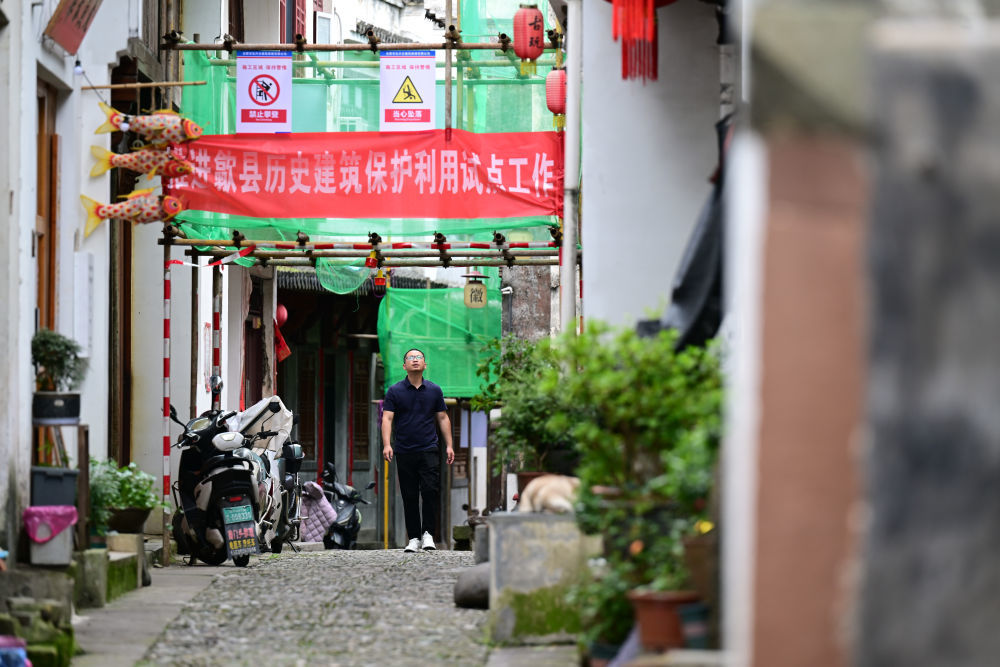 6月20日,周虎在歙县渔梁老街查看一处古民居的修缮情况。