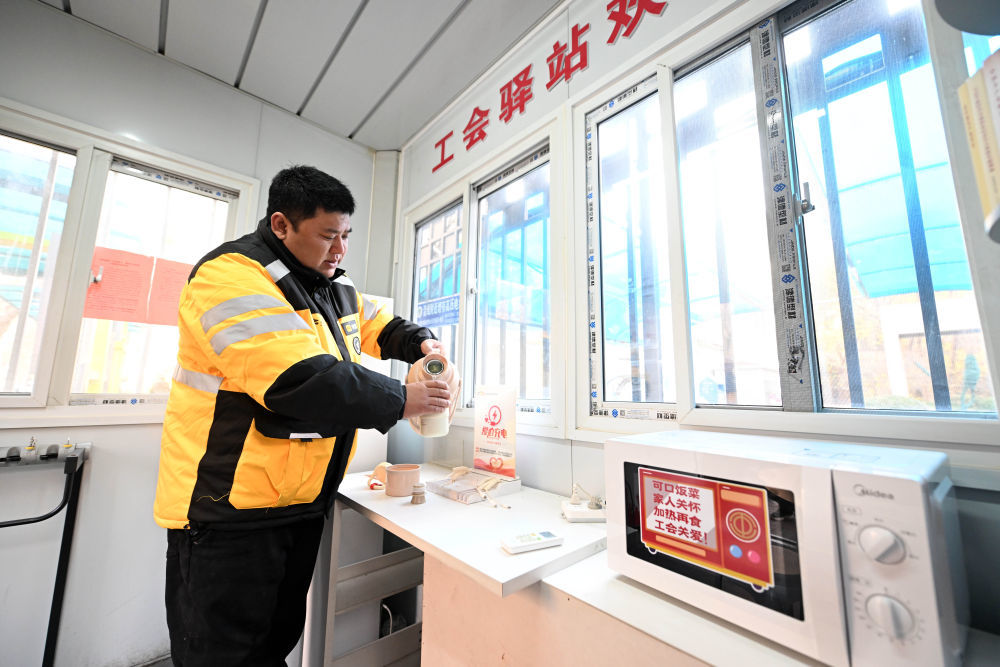 外卖小哥吴炎在南开大悦城工会驿站内接热水。新华社记者 赵子硕 摄