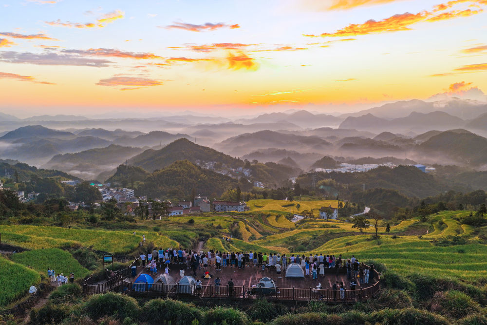 10月4日清晨,游客聚集在浙江省台州市天台县泳溪乡北山村的鎏金梯田观景台拍摄日出(无人机照片)。新华社发(林利军摄)