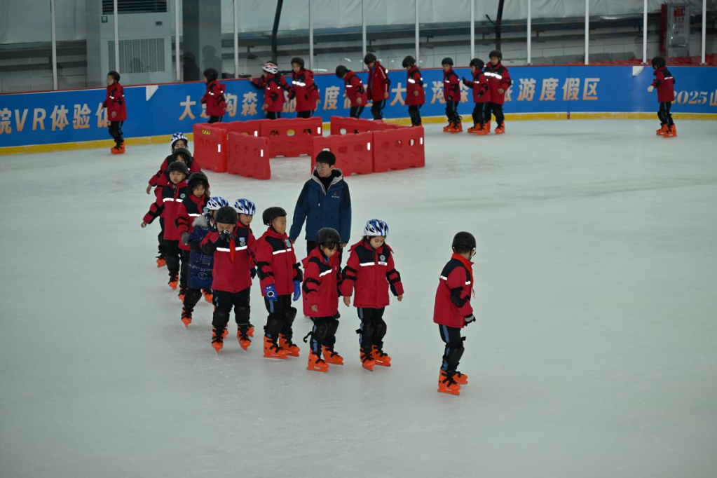 在王营庄文旅科创小镇气膜滑冰馆，离石区一所小学的孩子们在体验滑冰。新华网 发