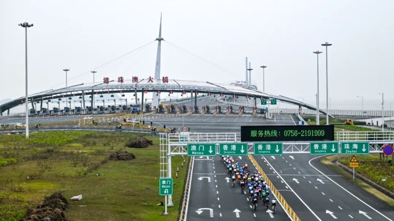 图为第十五届全国运动会公路自行车测试赛中，参赛选手无感通关通过港珠澳大桥