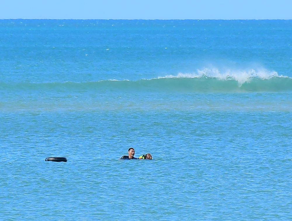 2025年6月15日，在坦桑尼亚达累斯萨拉姆市海边，张军桥（左）营救溺水的当地女子。新华社发