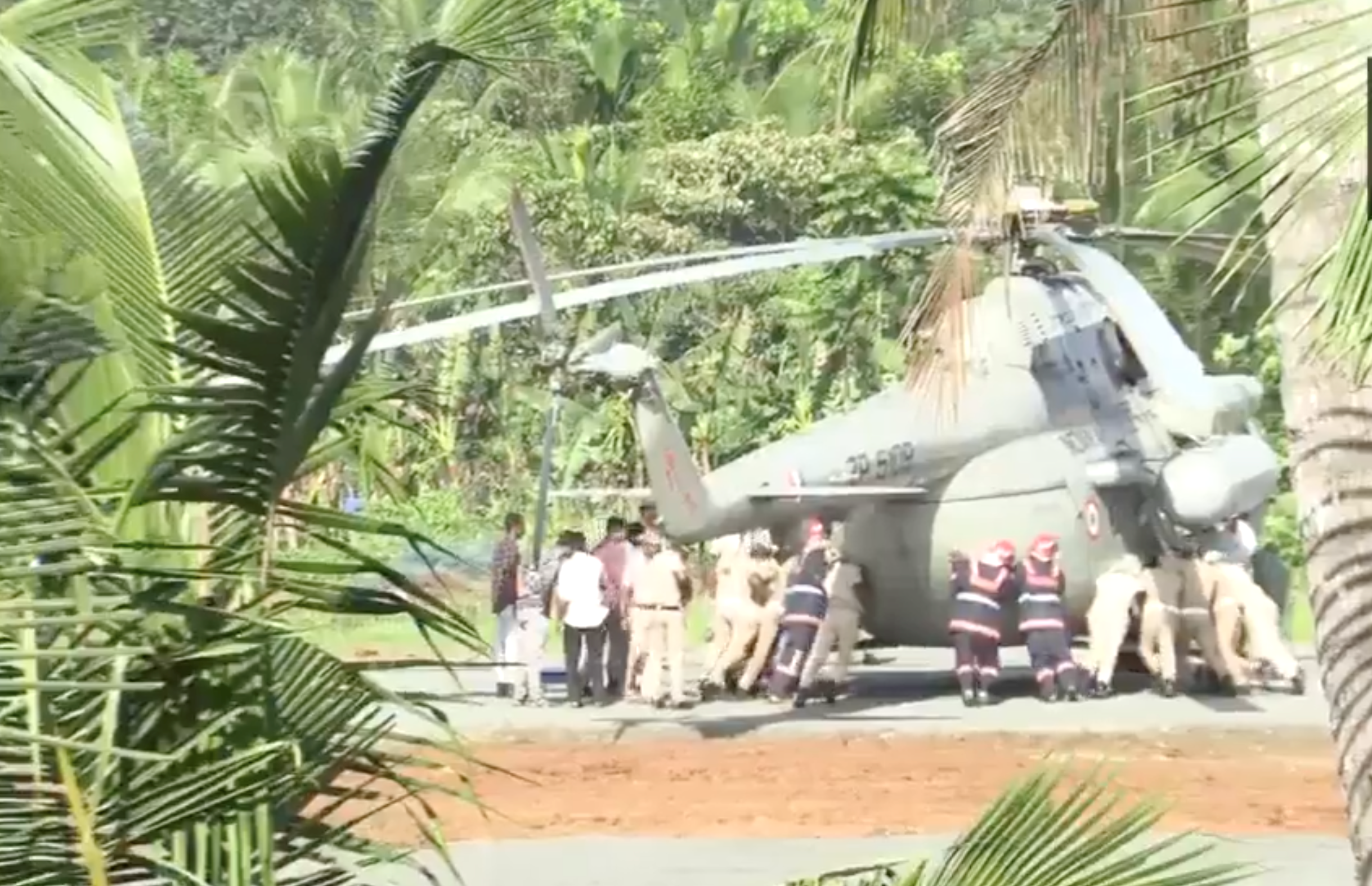 当地时间10月22日,印度警方和消防部门人员正徒手将印度总统直升机推出塌陷区域。 图源:新德里电视台视频截图