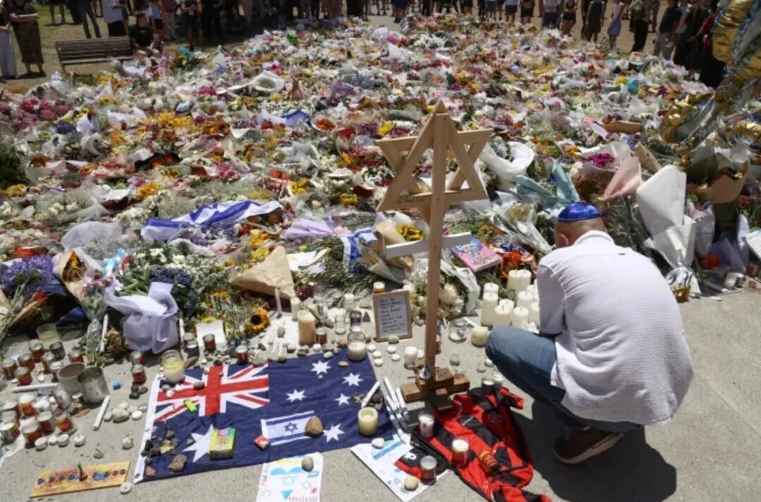 ◆12月17日,在邦迪海滩凉亭外,一名哀悼者点燃蜡烛纪念遇难者。