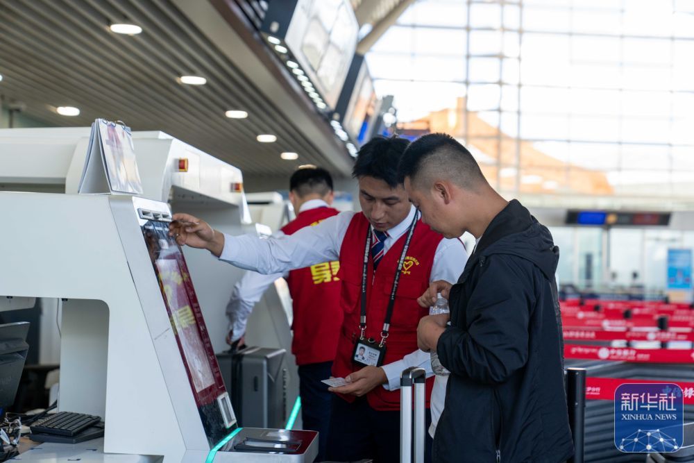 ↑ 7月18日，拉萨贡嘎国际机场工作人员在帮旅客办理行李托运手续。