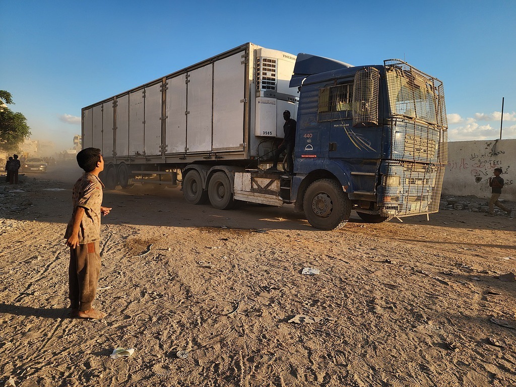 当地时间2025年10月12日,根据停火协议,载有人道主义援助物资和燃料的卡车通过凯雷姆沙洛姆口岸进入加沙地带,抵达汗尤尼斯。