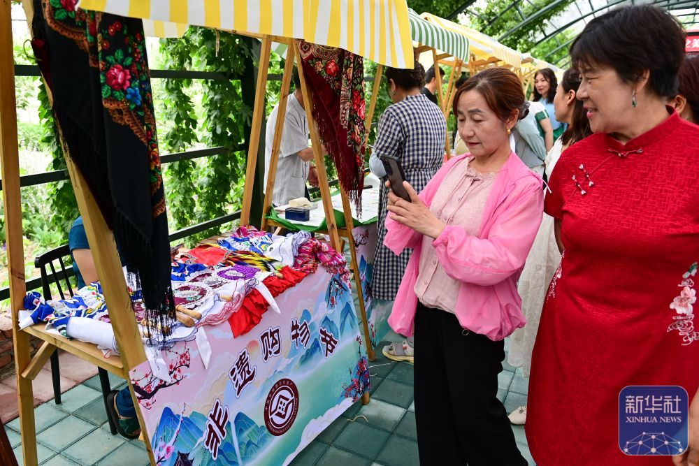 在新疆伊犁哈萨克自治州霍城县解忧公主薰衣草园，游客在非遗集市游览拍照（6月14日摄）。