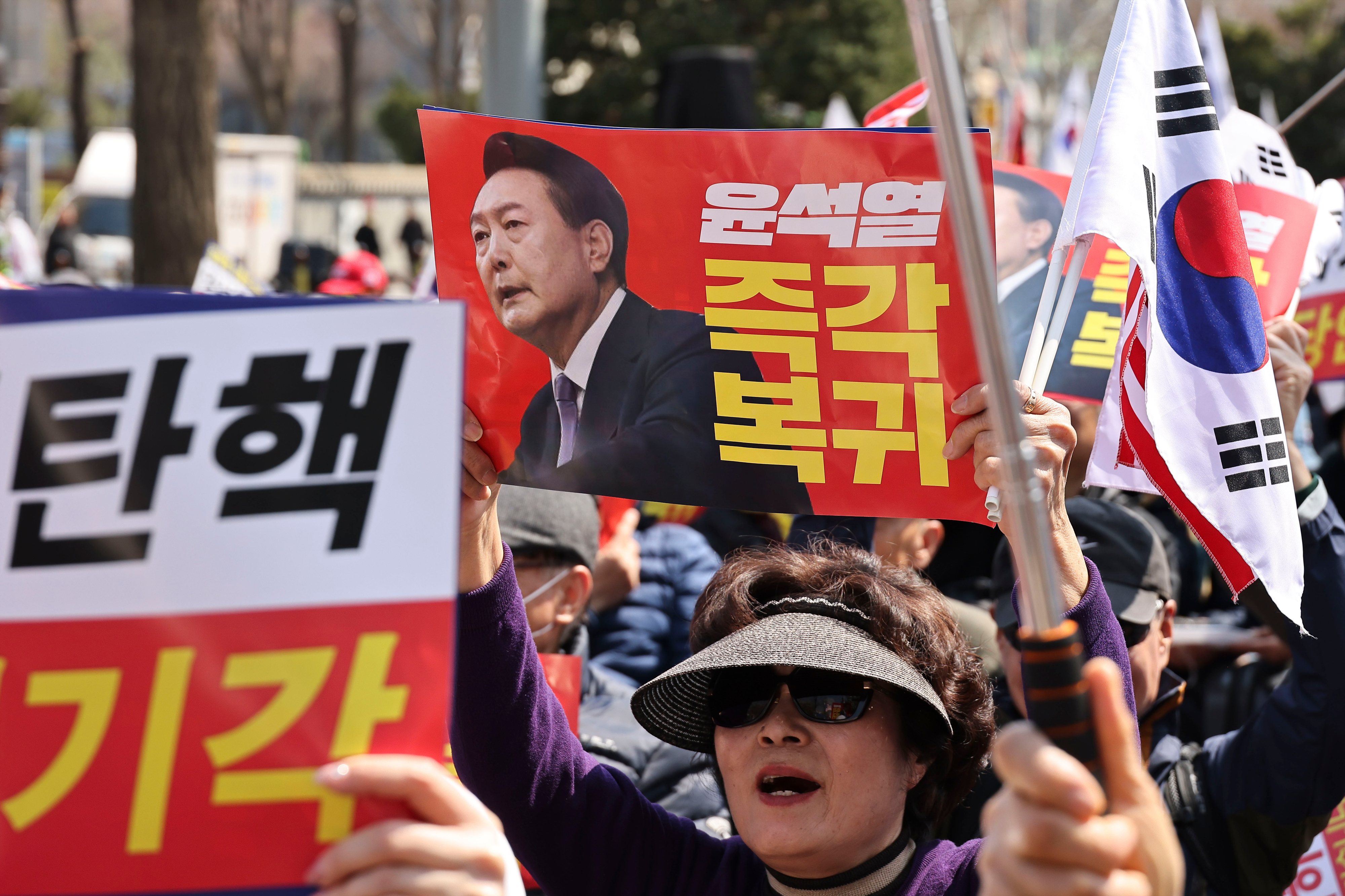 4月3日,在韩国首尔,尹锡悦支持者在韩国宪法法院附近示威要求驳回弹劾。牌子上写的是,欺诈性弹劾,应当被驳回。尹锡悦立刻回归。新华社发(全休相摄)
